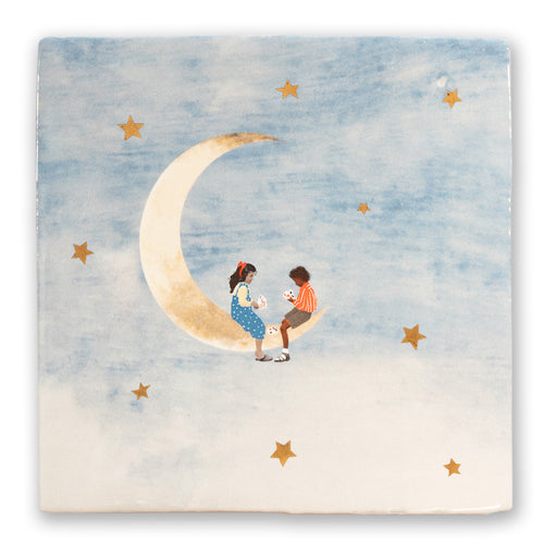 StoryTile Vriendjes op de Maan. Deze prachtige tegel laat een jongen en een meisje zien die een kaartspelletje spelen, terwijl ze op een maan zitten tussen de sterren. De maan en sterren zijn van goud. 