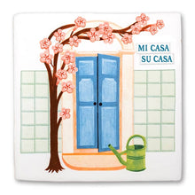 Afbeelding in Gallery-weergave laden, StoryTile - Mi casa es su casa. Tegel met blauwe deur en kersenbloesem. Naast de deur hangt de tekst: Mi Casa Su Casa. Voor de deur staat een groene gieter. 
