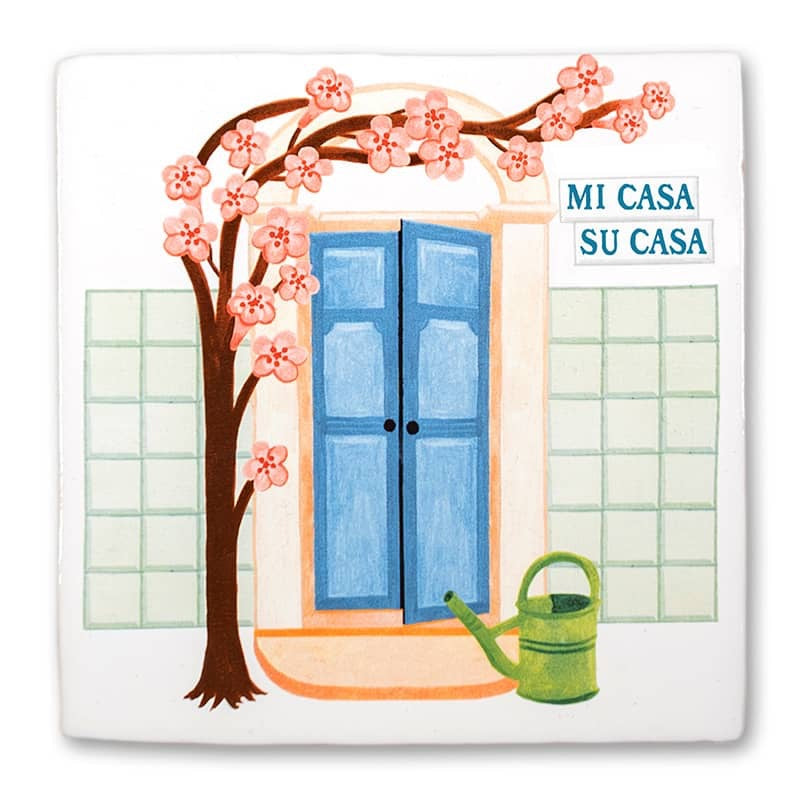 StoryTile - Mi casa es su casa. Tegel met blauwe deur en kersenbloesem. Naast de deur hangt de tekst: Mi Casa Su Casa. Voor de deur staat een groene gieter. 