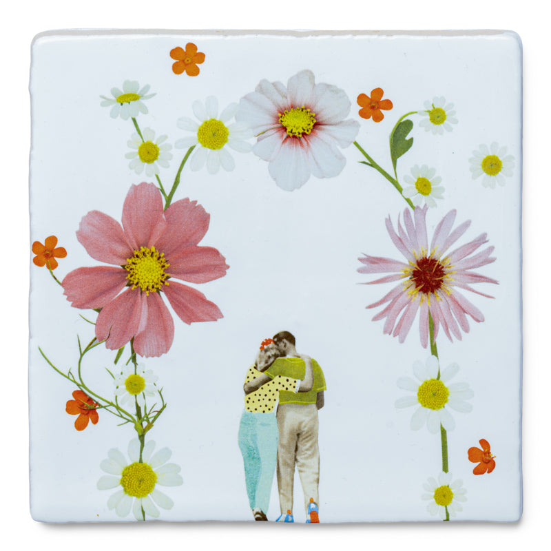 StoryTile Jij & ik: Onder een bloemenboog staan een man en vrouw in innige houding. De bloemen hebben de kleuren roze, oranje en wit met geel.